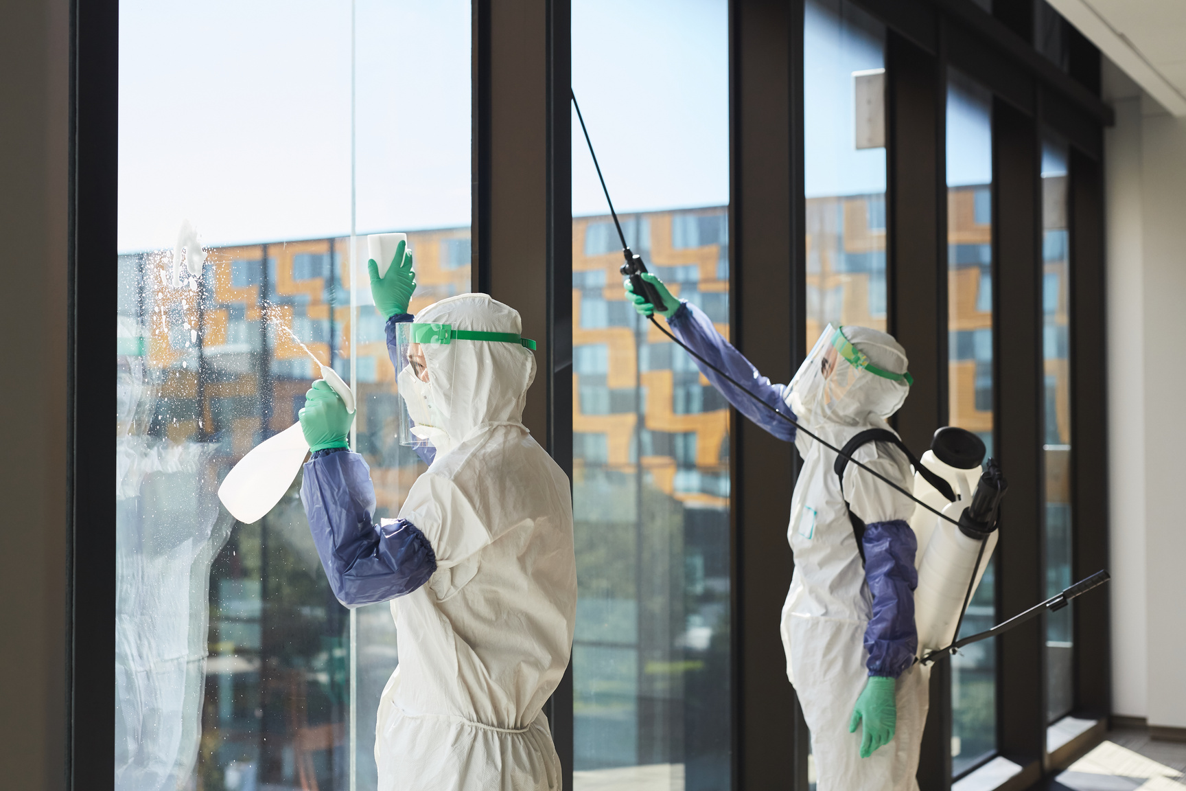 Cleaning Workers Disinfecting Windows in Office