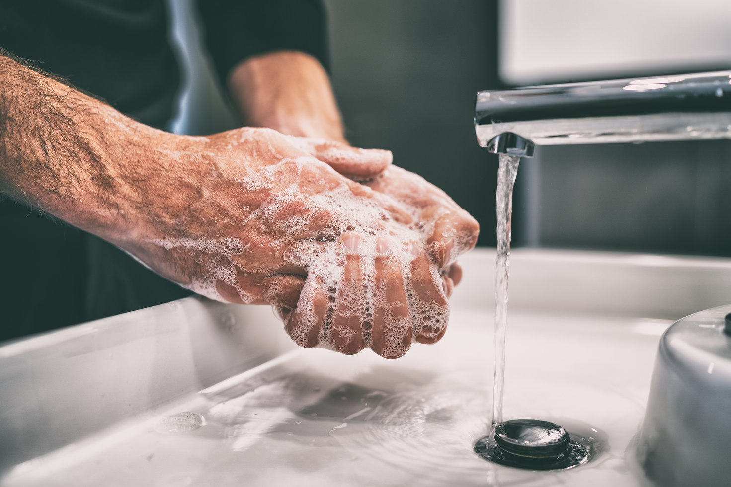 Man Washing Hands with Soap and Water in a Sink